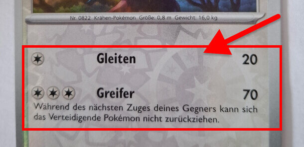 Nahaufnahme einer Pokémon-Karte mit zwei Attacken: „Gleiten“ mit 20 Schadenspunkten und „Greifer“ mit 70 Schadenspunkten. Eine rote Markierung hebt den Bereich der Attacken hervor.